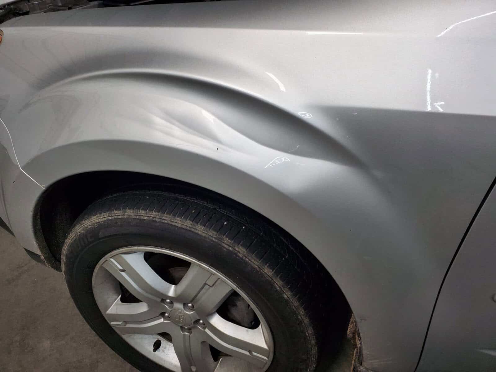 Subaru Forester fender with large deep crease dents