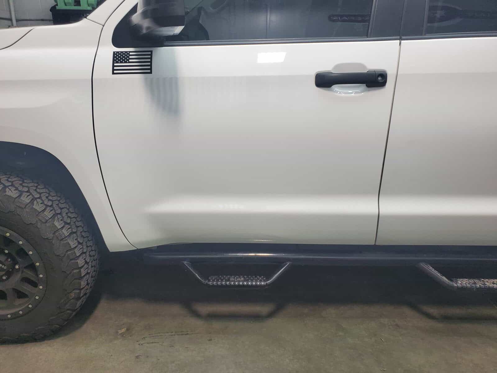 Autobody dent in body line of Toyota Tacoma restored using paintless dent removal and autobody repair techniques